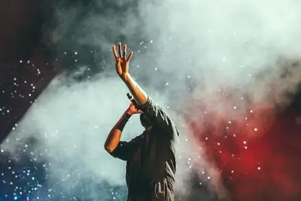 chanteur la main tendu dans un nuage de fumée à un concert