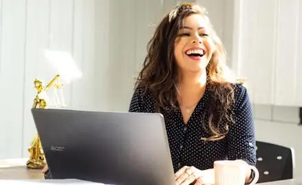 jeune fille souriante devant son ordinateur